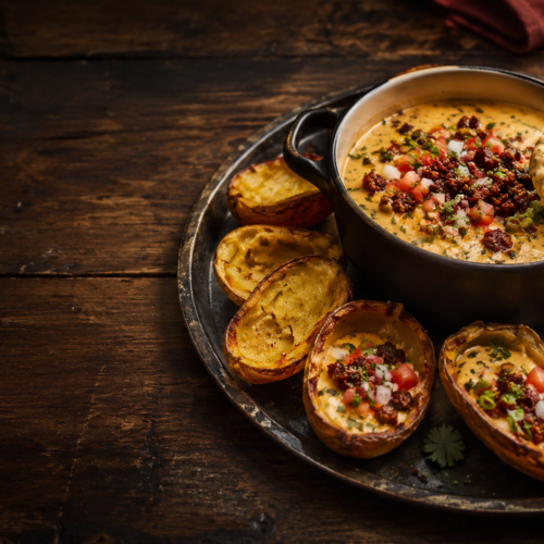 Loaded chorizo queso potato skins on a serving tray